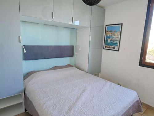 une chambre avec un lit dans une pièce blanche dans l'établissement Appartement T2 avec balcon vue port et accès piscine - FR-1-195-116, au Barcarès