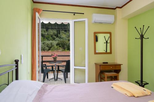 a bedroom with a bed and a table and a balcony at Remezzo Apartments in Sami