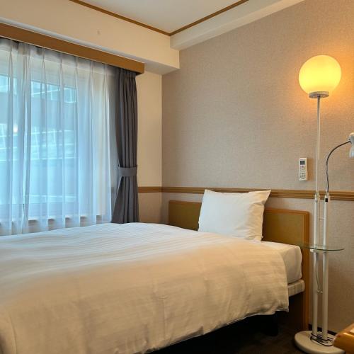 a hotel room with a bed and a window at Toyoko Inn Busan Station No.1 in Busan