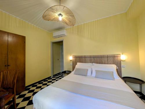 a bedroom with a large white bed with a checkered floor at Villa Fieschi Boutique Hotel in Lavagna