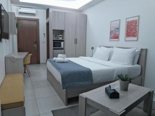 a bedroom with a large bed and a table at Shade Suites & Studios in Beirut
