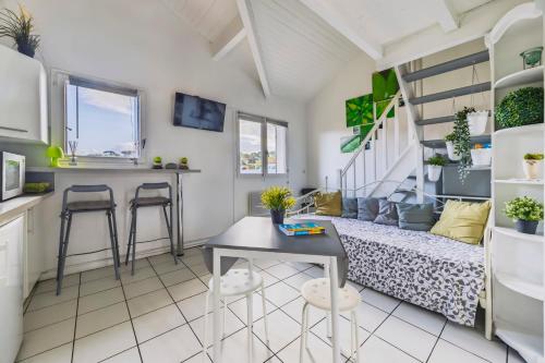 Ce petit appartement comprend un lit, une table et des chaises. dans l'établissement The Cocon de Biarritz, à Cambo-les-Bains
