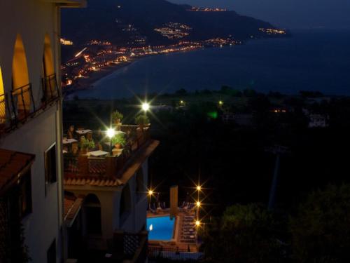 a view of a city at night with lights at Hotel Sirius in Taormina