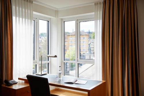 an office with a desk and a window with a view at Parkhotel Pforzheim in Pforzheim