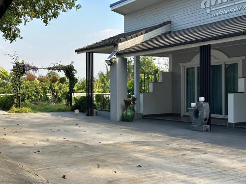 un portico di una casa con un vaso sopra di Sutalawadee Resort a Ban Prasat