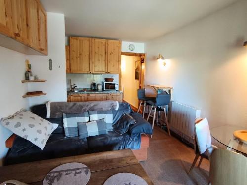 un salon avec un canapé et une cuisine dans l'établissement Résidence Le Sommet - Studio cosy avec terrase et jardinet pour 2 personne MAE-2984, à Montgenèvre