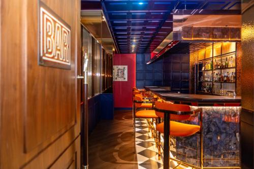 a bar with orange stools in a restaurant at Ramada by Wyndham Baden Hotel du Parc in Baden