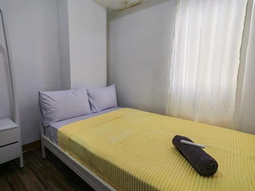 a small bedroom with a bed with a yellow blanket at Mailbox Arsakha Lobi B Cibubur Village in Cibubur