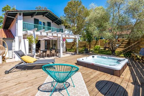 une arrière-cour avec un bain à remous sur une terrasse en bois dans l'établissement The Villa Harmonie, à Cambo-les-Bains