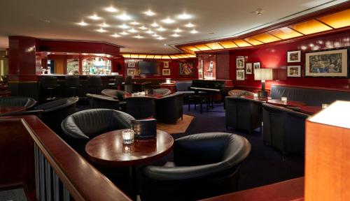 a bar with chairs and tables and a piano at Parkhotel Pforzheim in Pforzheim