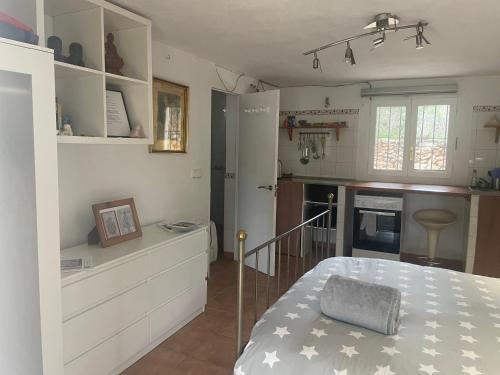 a small kitchen with a bed in a room at retreat studio in Santa Eularia des Riu
