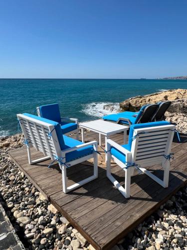 a group of chairs and a table on a dock at Golden Stone Beach in Halat Byblos