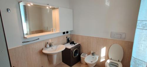 une salle de bains avec lavabo, toilettes et miroir dans l'établissement Villa Lago 5, à Sirmione