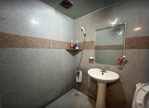 a bathroom with a sink and a mirror at Sangmu Green Hotel in Gwangju