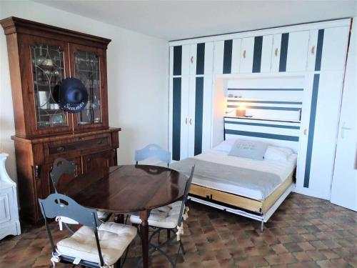- une chambre avec une table, un lit, une table et des chaises dans l'établissement Résidence Les Goëlands - T1 vue mer, emplacement idéal près du centre MAE-9474, à Arcachon