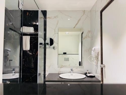 a bathroom with two sinks and a mirror at Mayur Belgaum Presidency Hotel & Spa in Belgaum
