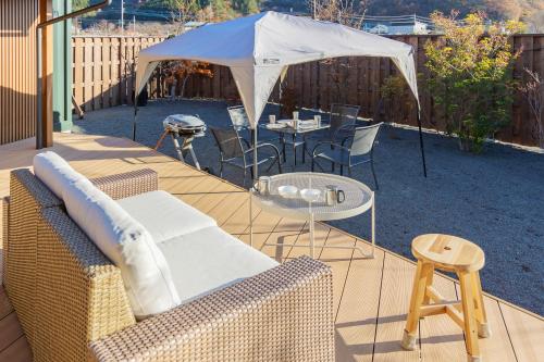 a patio with a table and chairs and a tent at 河口湖ベースキャンプ登り坂 in Fujikawaguchiko