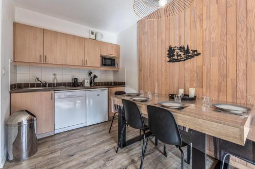 une cuisine avec une grande table et des chaises en bois dans l'établissement Résidence Le Balcon Des Airelles - Appartement calme au cœur des Orres 1800 MAE-6754, aux Orres