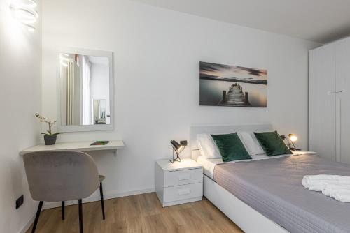 a white bedroom with a bed and a desk at Lecco - Luxury Lago e Centro a 3' Design & Netflix in Lecco