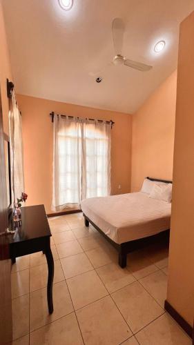a bedroom with a bed and a table and a window at Sicarú Suites in Puerto Escondido