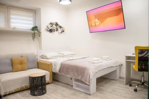 mała sypialnia z łóżkiem i kanapą w obiekcie Eight Lamps 'n Floor Heating w Zagrzebiu