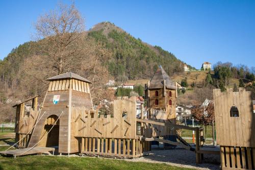 a playground in a park with a wooden play structure at Apartments Artorius Laško in Laško