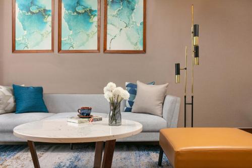 a living room with a couch and a table at Mövenpick Living West Hanoi in Hanoi