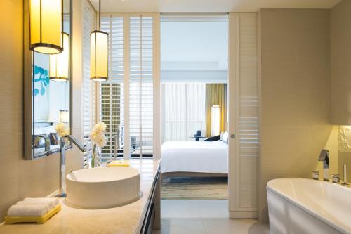 a bathroom with a tub and a bedroom with a bed at Renaissance Sanya Haitang Bay Resort in Sanya