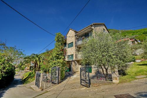 an old house with a fence in front of it at Apartments Dinko Zifra in Tivat