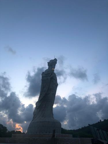 a large statue in front of a cloudy sky at 大梅石創生共享家士兵館 in Ma-tsu Tao