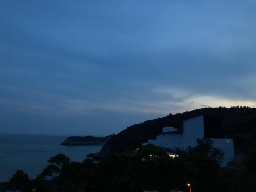 a building on a hill next to the ocean at 大梅石創生共享家士兵館 in Ma-tsu Tao