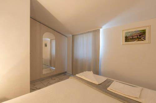 sypialnia z łóżkiem i lustrem w obiekcie Apartments LIMIA w Puli