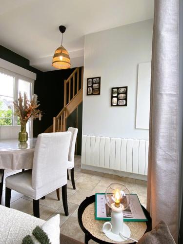 un salon avec une table et une salle à manger dans l'établissement Maison 2 chambres avec parking et jardin, à Noyon