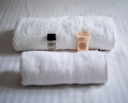 deux serviettes et une bouteille de lotion posées sur un lit dans l'établissement Mobility lease - 10 minutes from Paris - 1BD, à Boulogne-Billancourt