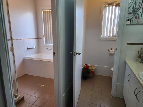 a bathroom with a bath tub and a sink at Goolwa Getaway in Goolwa