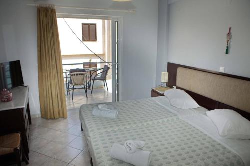 a bedroom with a large bed with towels on it at Eleni's Summer Apartment in Tolo