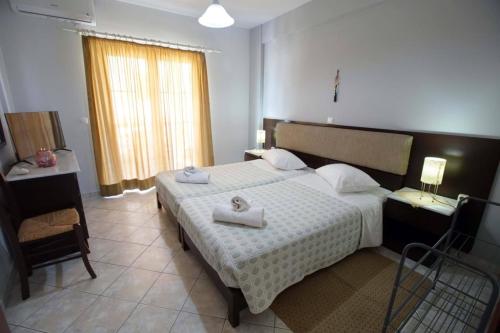 a bedroom with a bed with two towels on it at Eleni's Summer Apartment in Tolo