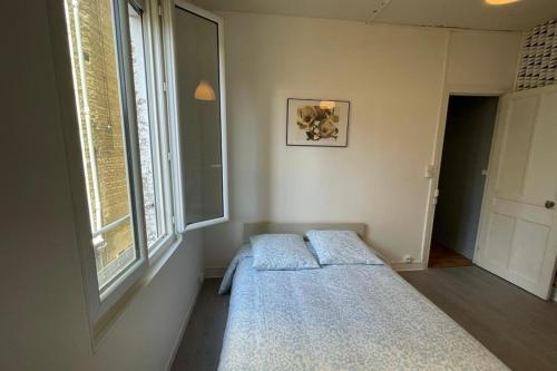 une chambre avec un lit et une fenêtre dans l'établissement Le nid Havrais, au Havre