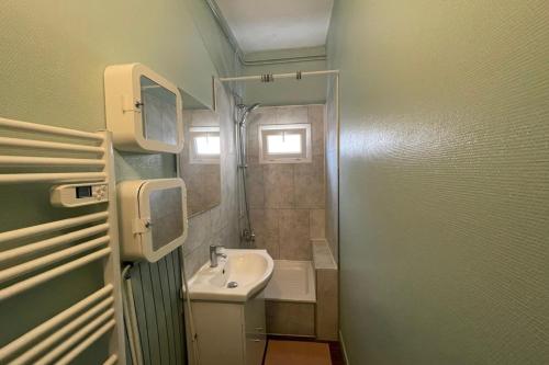 une petite salle de bain avec un lavabo et une douche dans l'établissement Le nid Havrais, au Havre