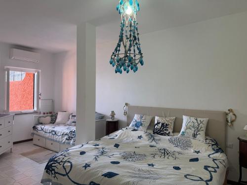 a bedroom with a bed and a chandelier at Vista Mare in Porto Santo Stefano