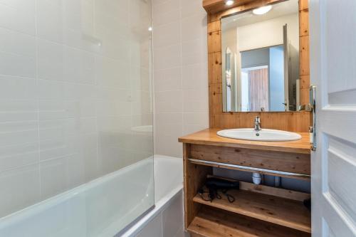 une salle de bain avec un lavabo, une baignoire et un miroir dans l'établissement Résidence Le Balcon Des Airelles - Appartement chaleureux au coeur des Orres 1800 MAE-3661, aux Orres