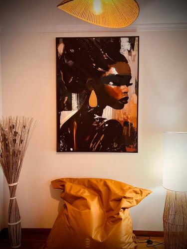 a painting hanging on a wall next to a bed at Apartamento Janela do Atlantico in Machico