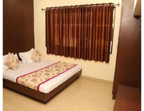 a bedroom with a bed and a window with curtains at Hotel heena plaza, mount abu in Mount Ābu
