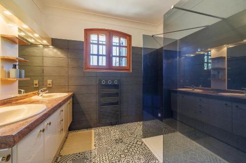 a bathroom with two sinks and a tub and a window at La Châtelaine - A 25min de St Emilion in Saint-Seurin-sur-lʼIsle