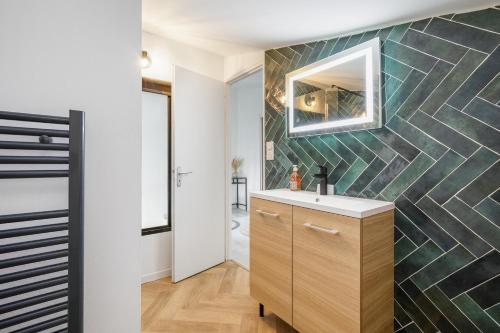 une salle de bain avec un lavabo et un miroir sur un mur dans l'établissement Cap Soleil - Vue port proche de la plage, au Cap d'Agde