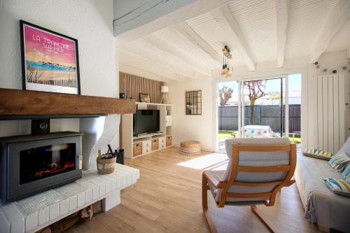 un salon avec une cheminée et une télévision dans l'établissement Le Murmure des Vagues - Proche plage, à La Tranche-sur-Mer