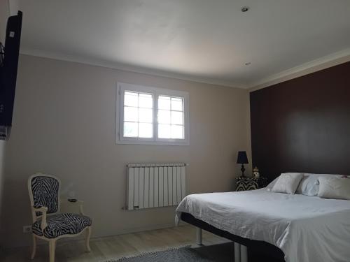 une chambre avec un lit, une fenêtre et une chaise dans l'établissement Villa provençale avec jacuzzi, à Entraigues-sur-la-Sorgue