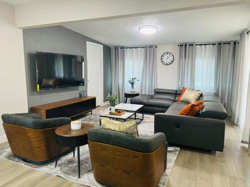 a living room with couches and a flat screen tv at Entire House near DTLV in Las Vegas
