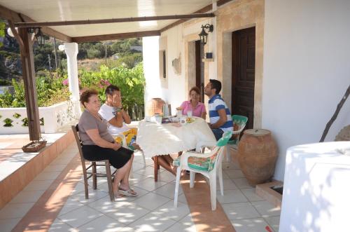 a group of people sitting around a table on a patio at La Villa di Zazopetra in Menetaí