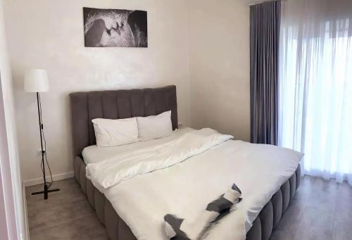 a bedroom with a large bed with white sheets at Bright Gray Нові затишні апартаменти біля центру in Ternopilʼ